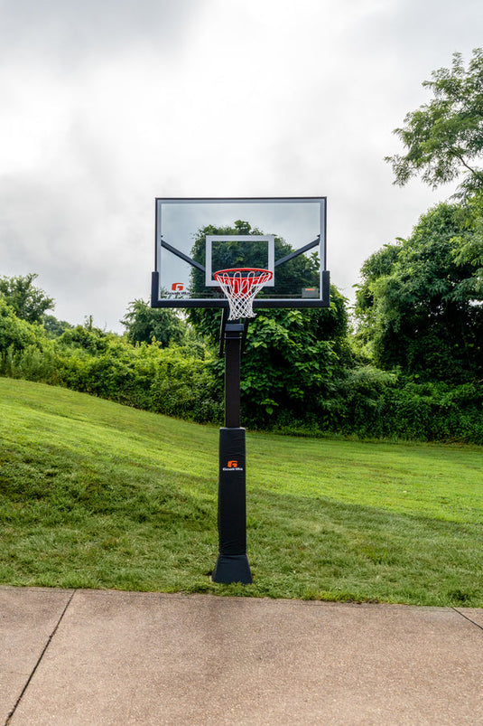 Basketball hoop on a grassy area with trees in the background
