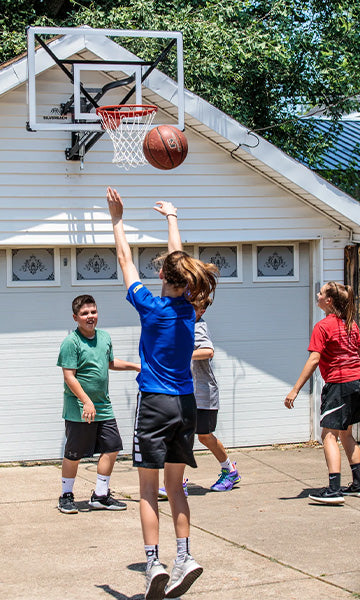 Kids playing basketball in their backyard